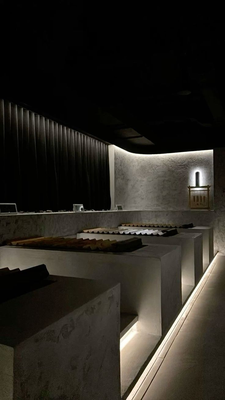 A minimalist concrete sauna interior, lit by a single warm strip of light.